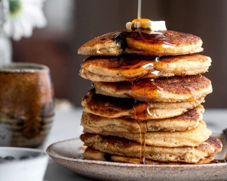 Stack of blueberry kefir pancakes with syrup.